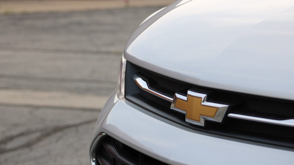 Na frete de um carro, em metal, está a marca figurativa da empresa fabricante